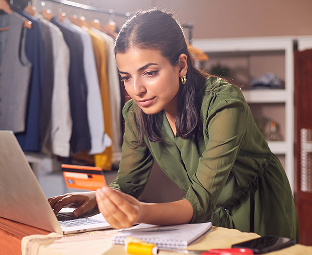 A woman using omnichannel payment processing systems to pay for inventory on her laptop