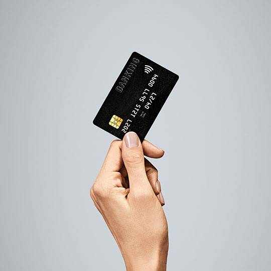 A hand holding a debit card